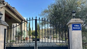 A gated entrance to Villa Helene with a clear view of the surrounding architecture and landscape.