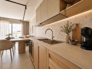 A modern kitchen with a large window, a dining area, and a coffee machine.