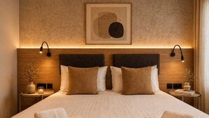 A hotel room with a large bed, two bedside tables, a wall-mounted artwork, and a headboard with integrated lighting. - Exclusive Retreat off the Sea Front Promenade (Il-Gzira)