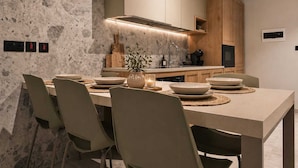 A modern kitchen with a central island, built-in cabinets, and a stone backsplash. - Exclusive Retreat off the Sea Front Promenade (Il-Gzira)