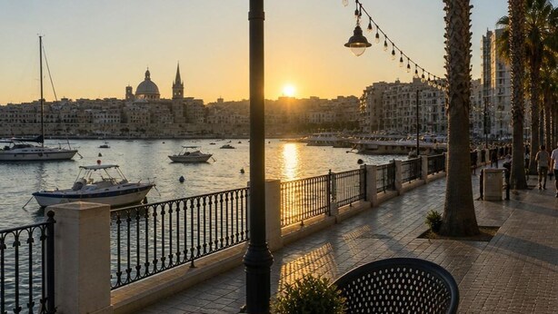 A waterfront dining area with a table and chairs, a railing, and a view of the sea and cityscape. - Exclusive Retreat off the Sea Front Promenade (Il-Gzira)