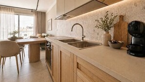A modern kitchen with a large window, a dining area, and a coffee machine. - Exclusive Retreat off the Sea Front Promenade (Il-Gzira)