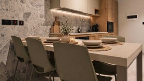 A modern kitchen with a central island, built-in cabinets, and a stone backsplash. - Exclusive Retreat off the Sea Front Promenade (Il-Gzira)