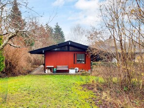 A red cabin with a small porch, a bench, and a table. - Riverside Retreat in Rageleje - By Traum Ferienwohnungen (Vejby)