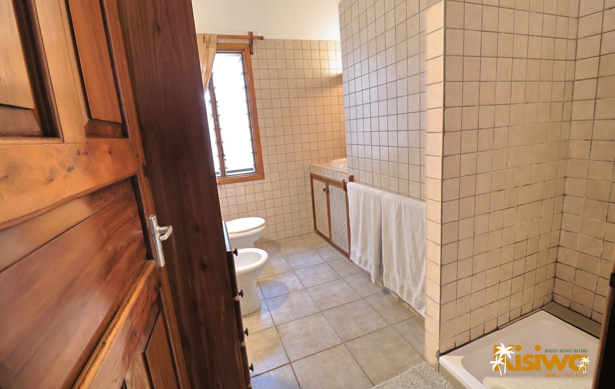 Baño con inodoro, lavabo y zona de ducha.