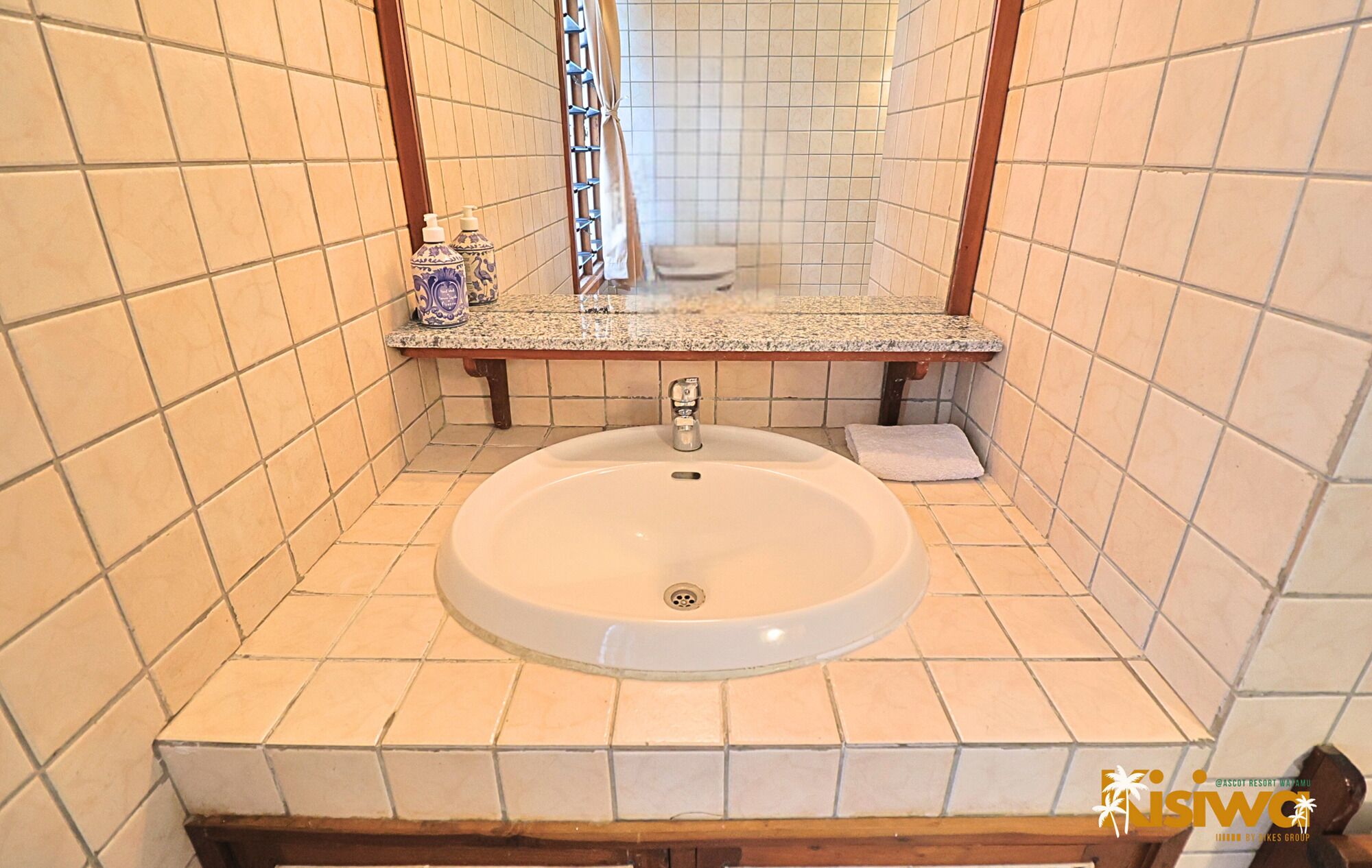 A bathroom with a white sink, a mirror, and a towel rack.