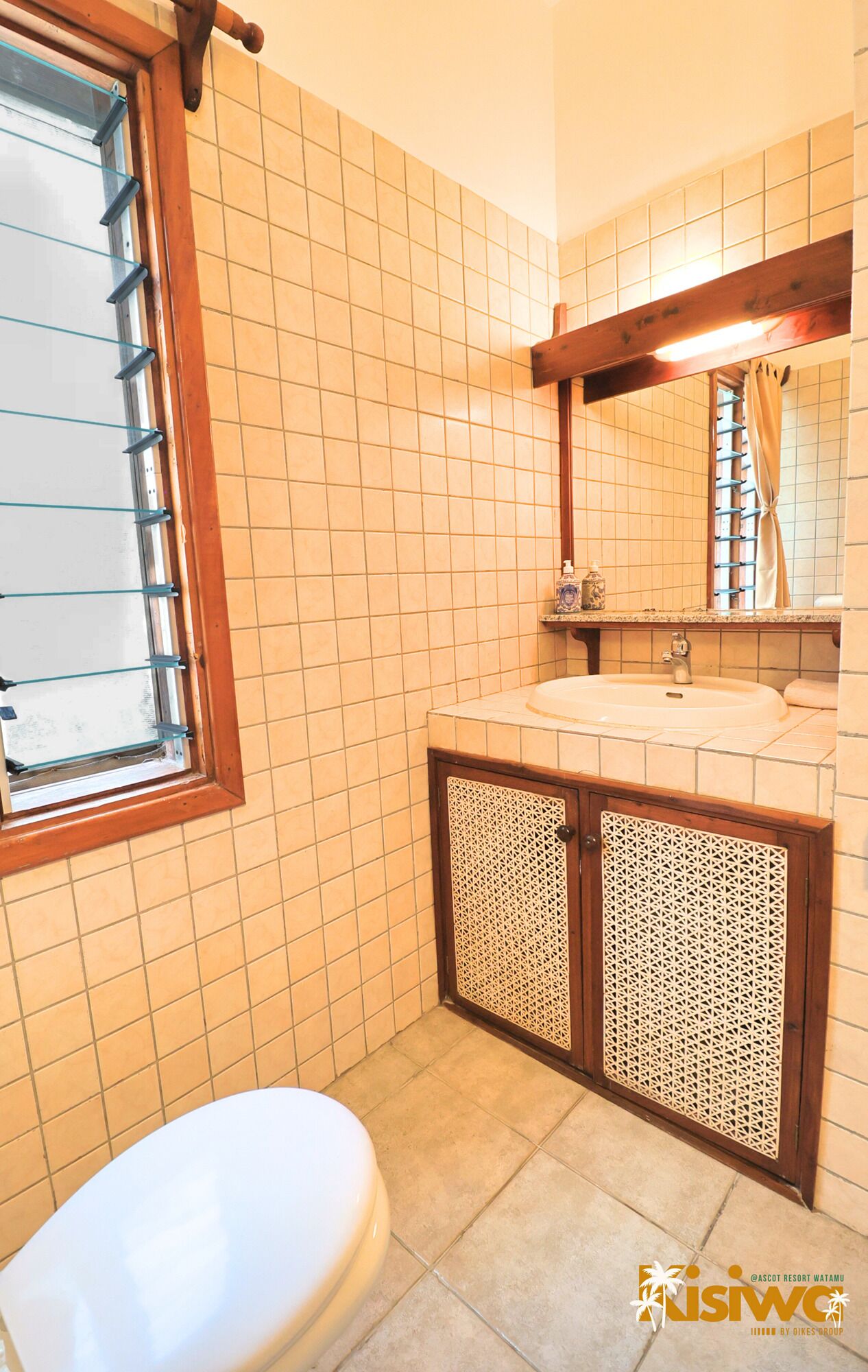 A bathroom with a toilet, a sink, and a window with blinds.