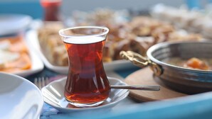 A table with a glass of tea, a bowl of soup, and various dishes. - ADA LUNA BOZCAADA (Bozcaada)