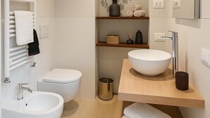 Un baño moderno con dos lavamanos, un inodoro y un espejo.