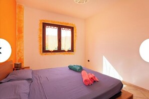 Relax in a spacious room with a large bed and a window with a decorative frame.