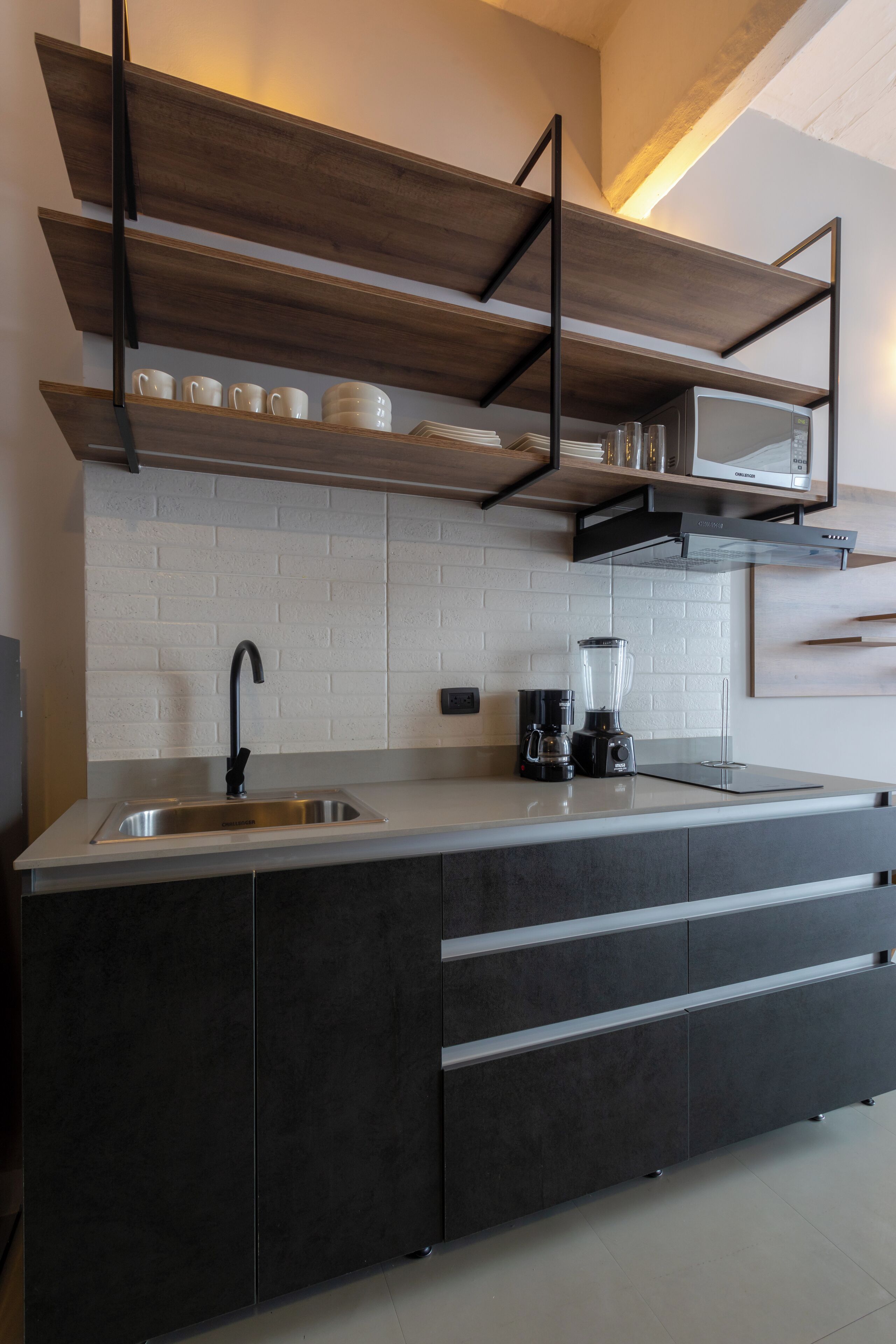 A modern kitchen with a built-in sink, a coffee maker, and a blender on the counter.
