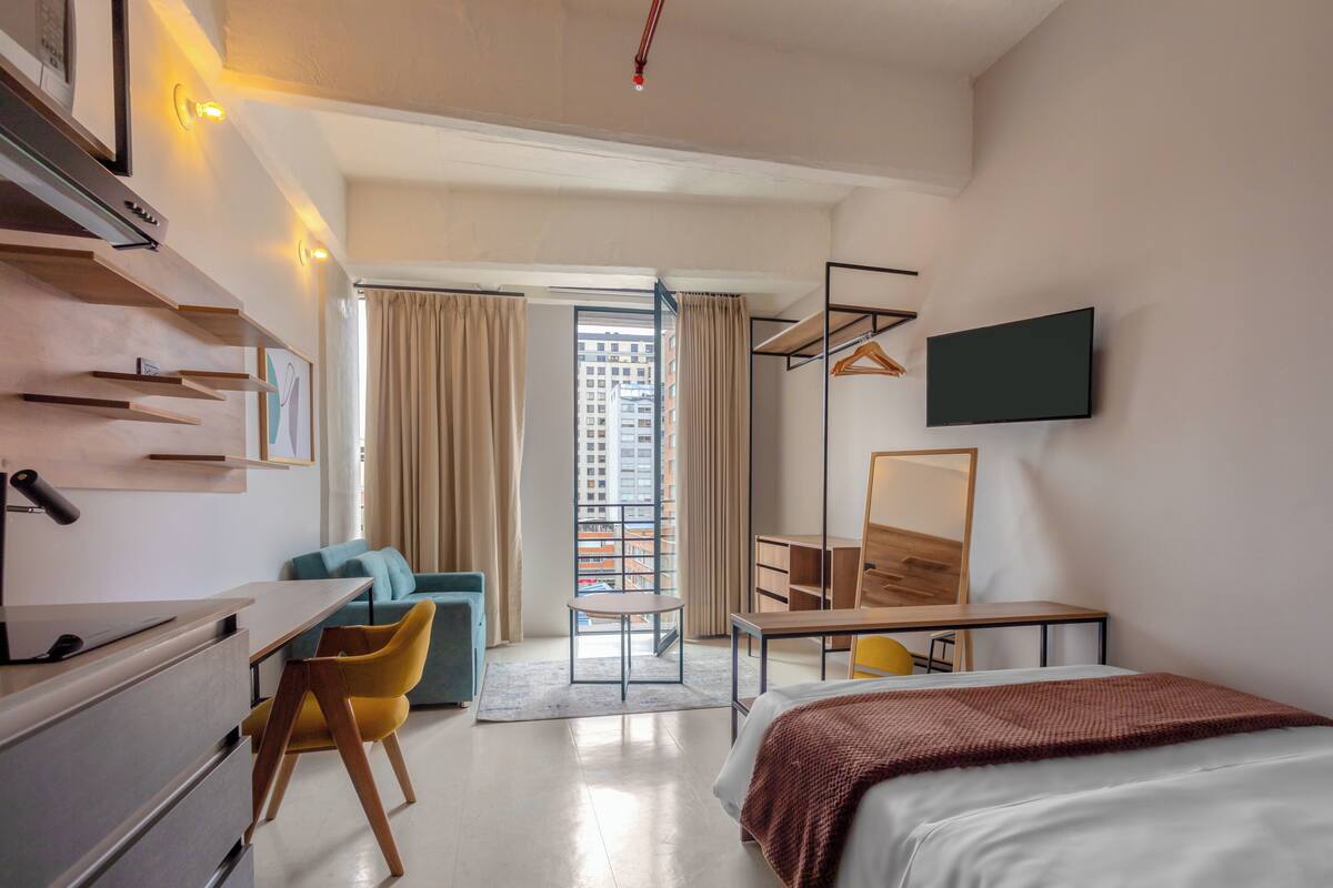 Ein modernes Hotelzimmer mit Bett, Schreibtisch und Sitzecke.