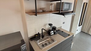 A modern kitchen with a built-in dishwasher, a coffee maker, and a microwave. - Ivin 567 by Atelier (Bogotá)