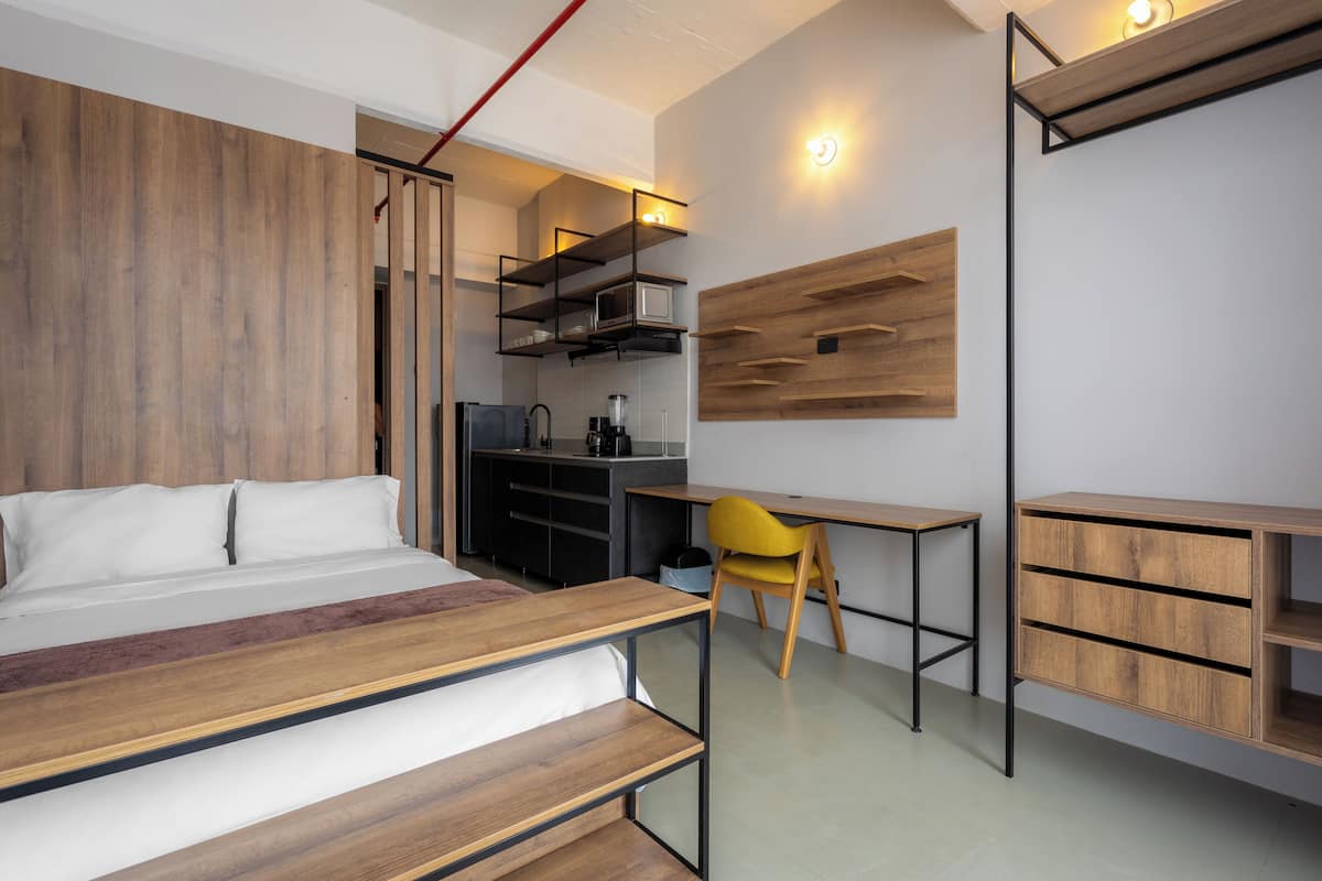 Ein modernes Schlafzimmer mit einem Holzbett, einem Schreibtisch und einem Stuhl.
