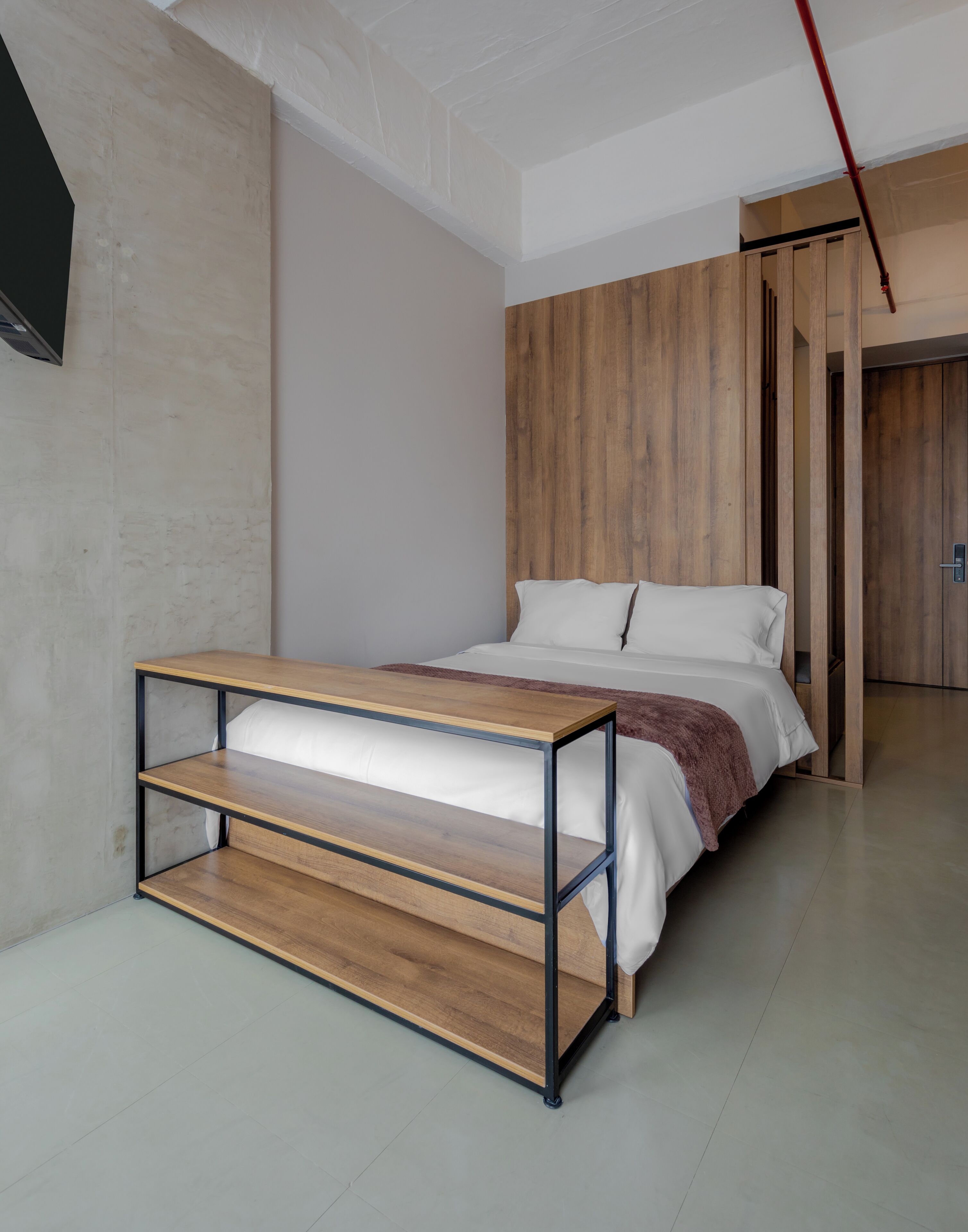 Un dormitorio moderno con una cama, una mesita de noche de madera y un armario.