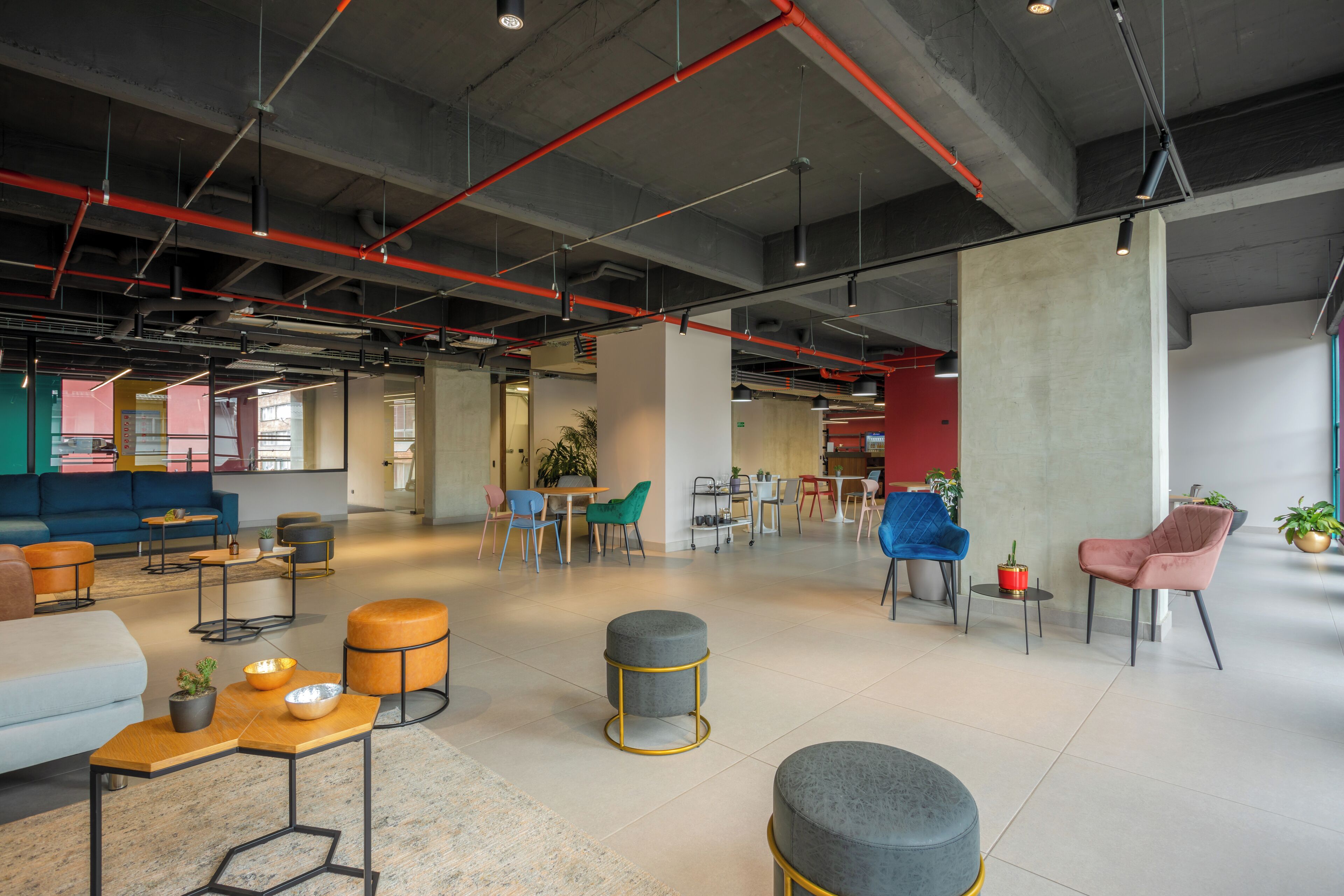 A spacious, modern lounge area with comfortable seating, a coffee table, and a large pillar.