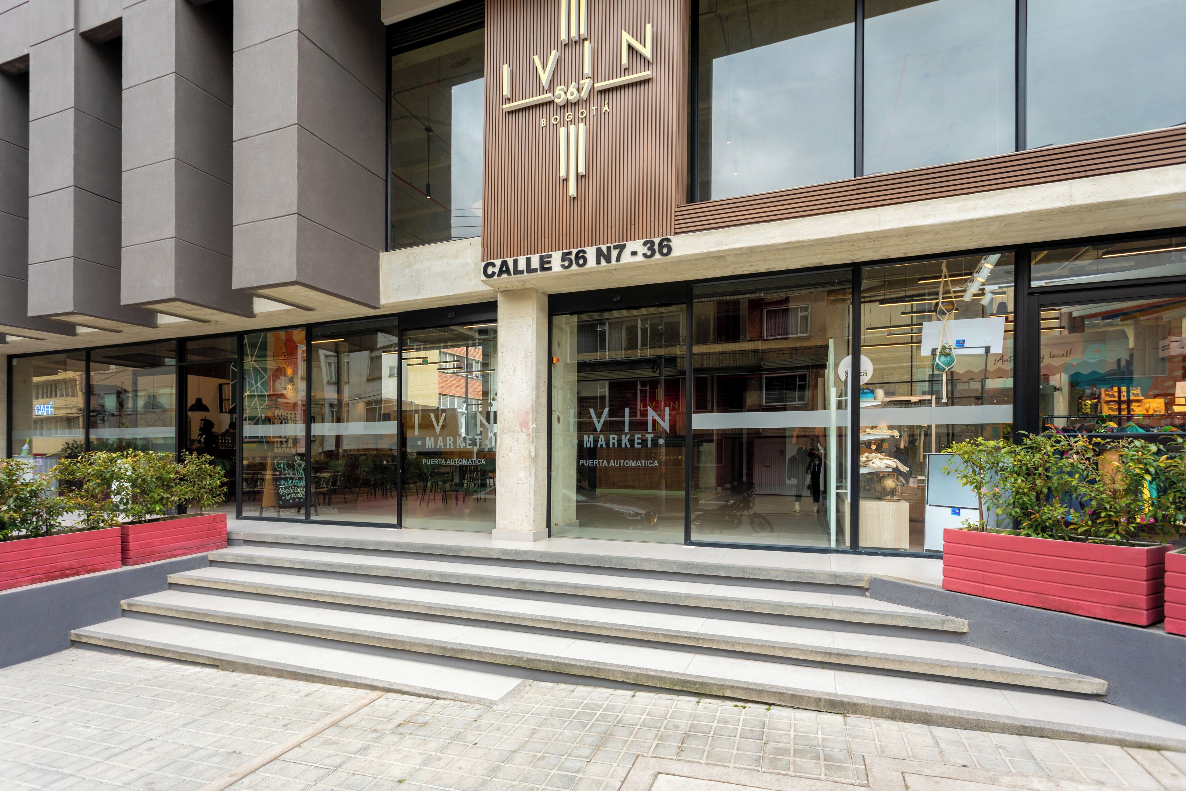 Ein modernes Gebäude mit einem gut sichtbaren Schild, auf dem „LIVIN MARKET“ und „Calle 56 N7-36“ steht.
