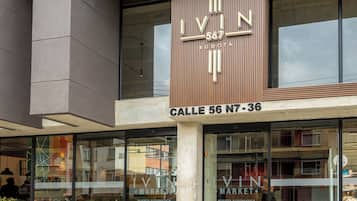 A modern building with a prominent 'IVIN MARKET' sign, featuring a vertical design with the number '567' and 'BOGOTA' below. The entrance has glass doors and a visible street name 'Calle 56 N7-36'.