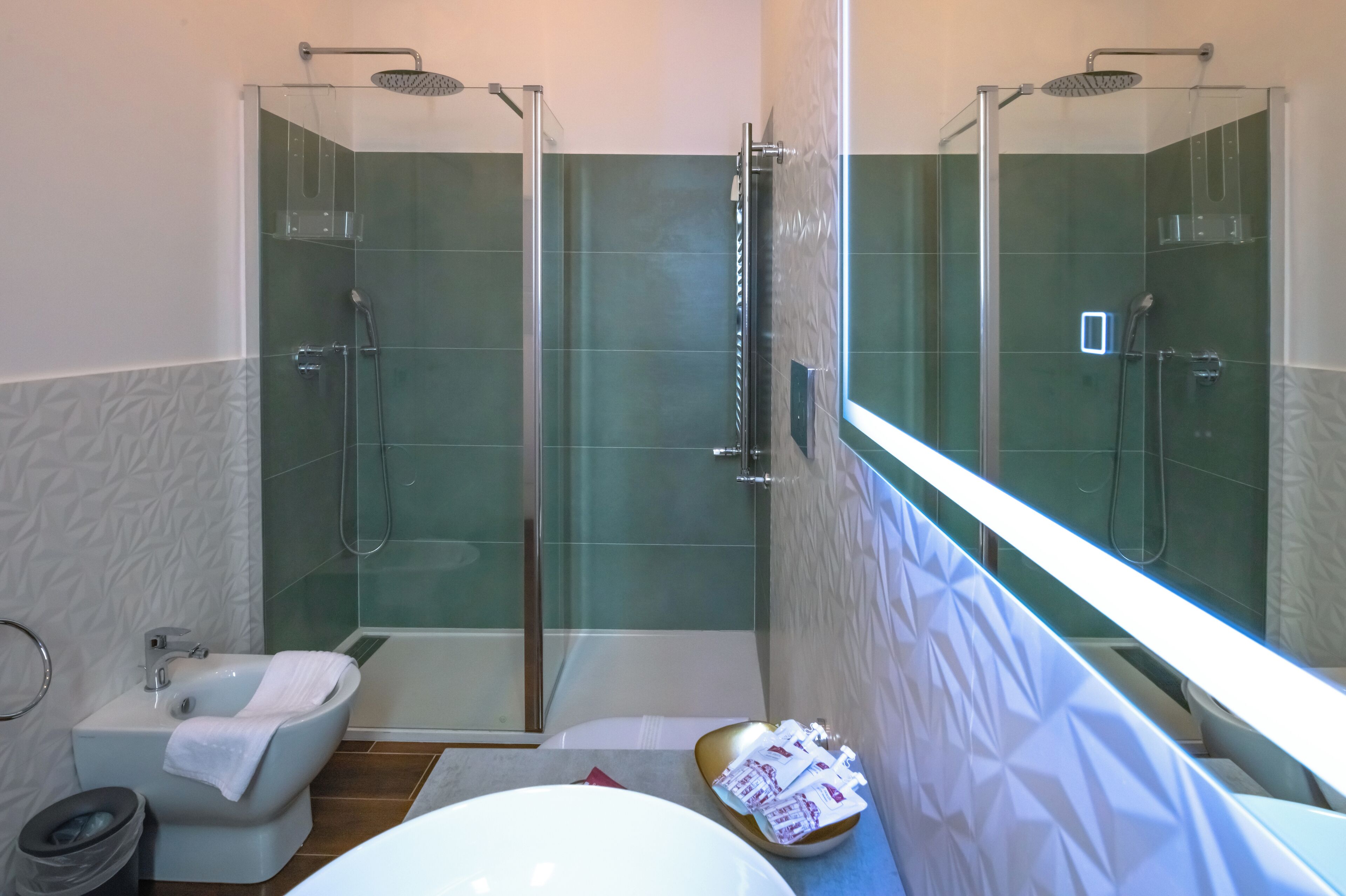 A modern bathroom with a glass-enclosed shower, a bidet, and a bathtub.