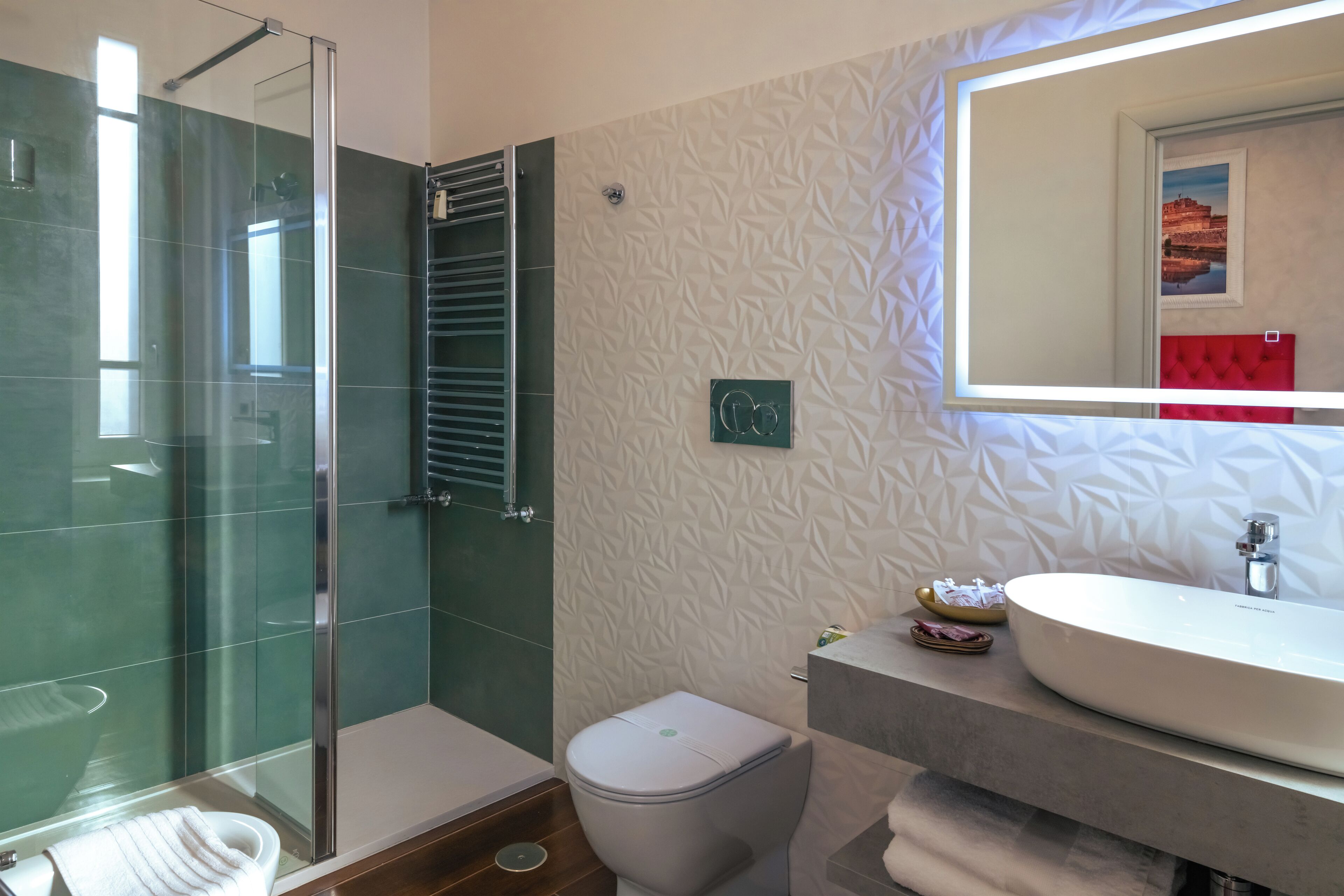 Un baño moderno con ducha de vidrio, inodoro blanco y un lavamanos grande con un espejo encima.