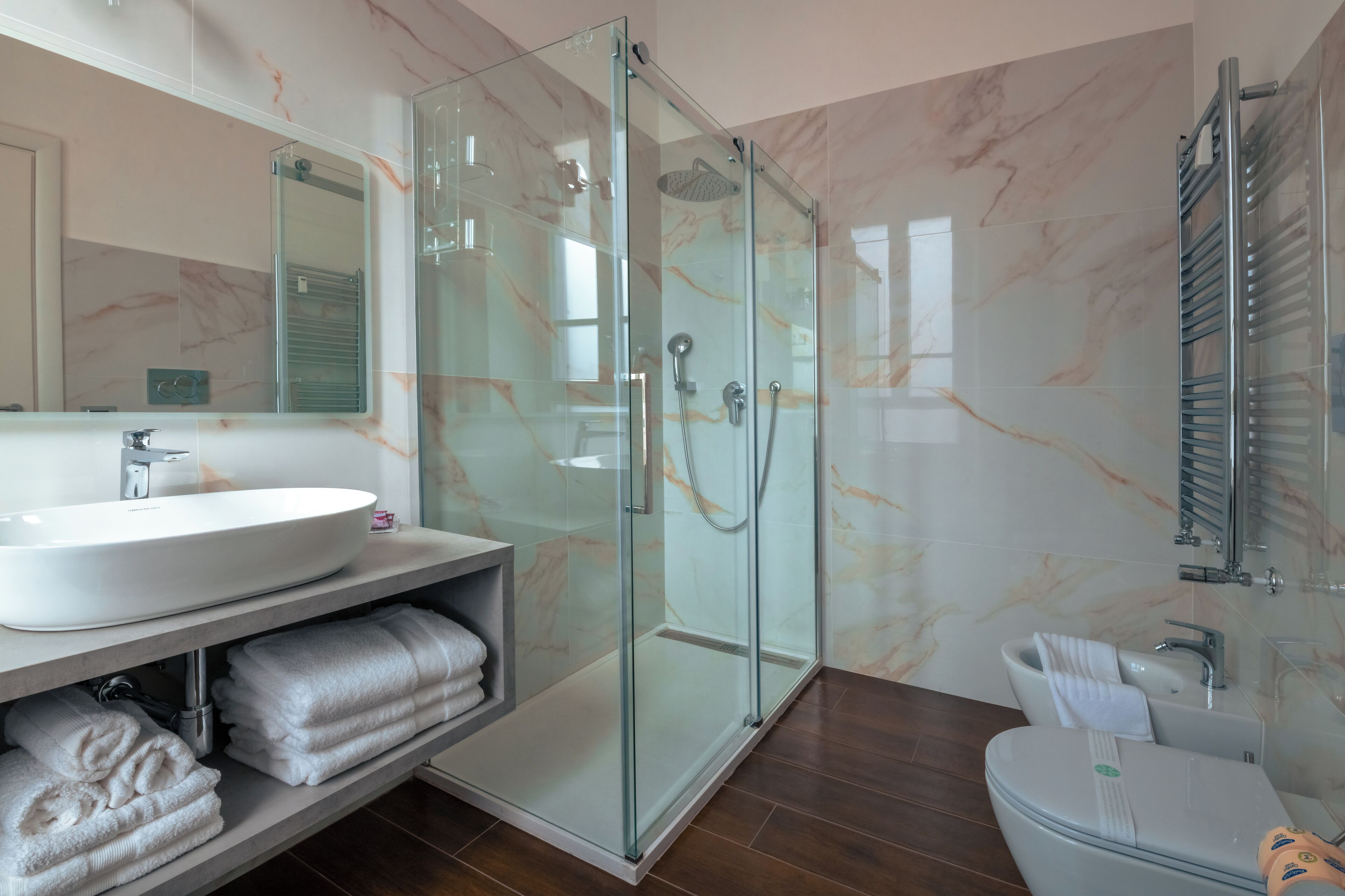 Une salle de bain moderne avec une douche à parois de verre, un lavabo blanc et des toilettes.