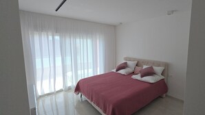 A bedroom with a bed, white curtains, and a light-colored floor. - Holiday house in northern dalmatia (Zadar)