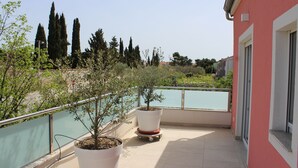 A balcony with potted plants and a view of a body of water and trees. - Holiday house in northern dalmatia (Zadar)