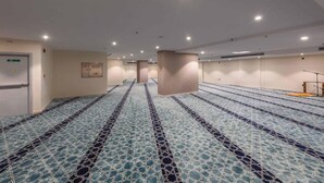 Una habitación amplia con piso estampado, un mostrador de recepción y una puerta.