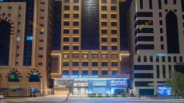 Un hotel con una entrada llamativa, varios pisos y una fachada moderna.