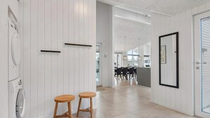 Ein modernes Interieur mit Küchenbereich, Holzschemeln und einem Esstisch.