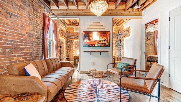 A cozy living room with a leather sofa, a round rug, and a wooden coffee table.