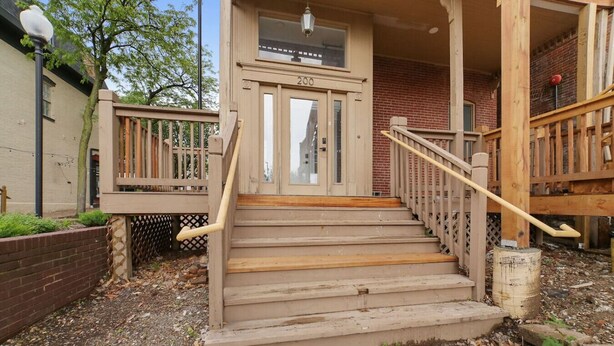 A wooden staircase leading to a building entrance with a number '200' above the door.