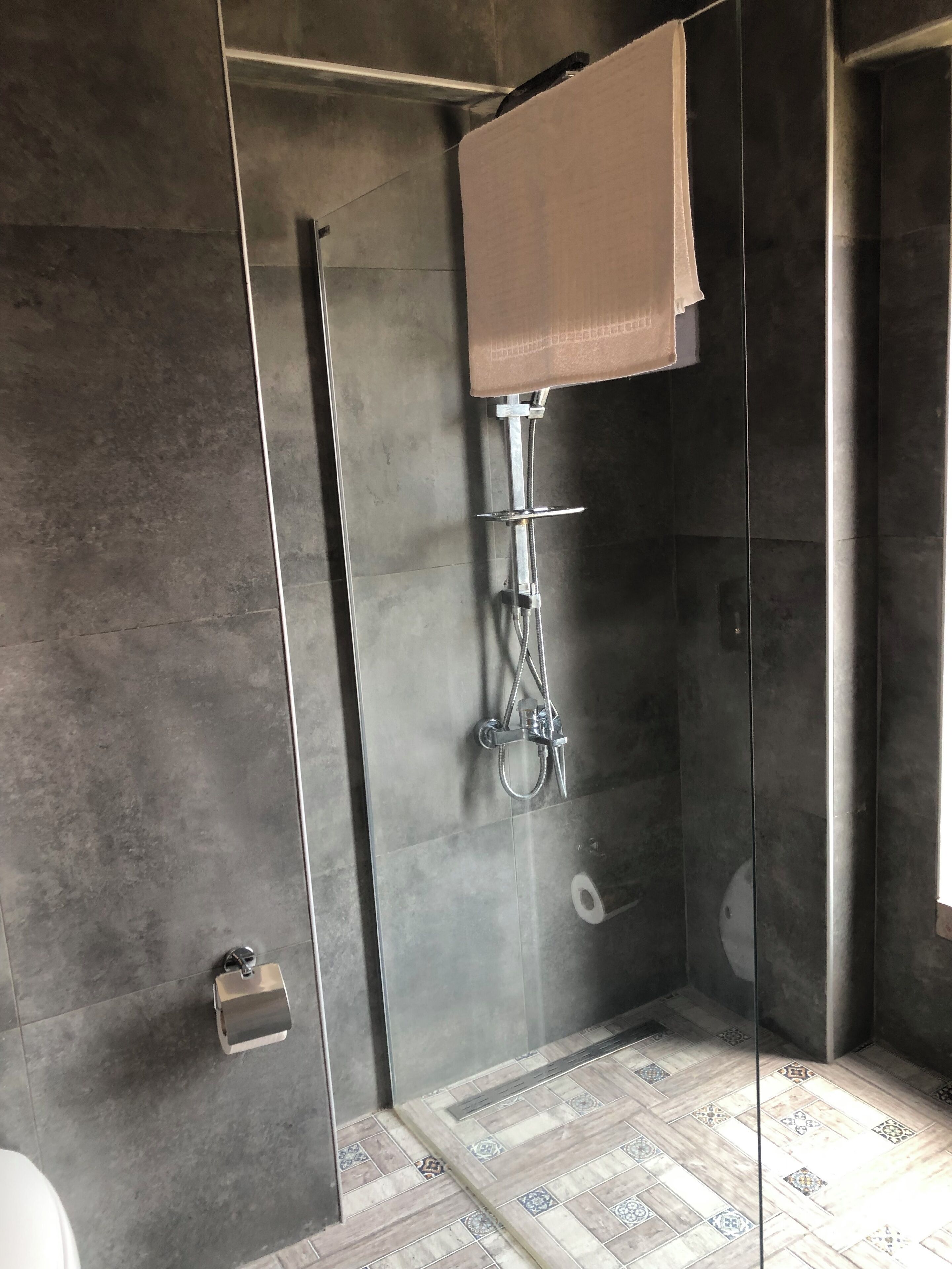 Un baño moderno con ducha de vidrio, inodoro y lavamanos.