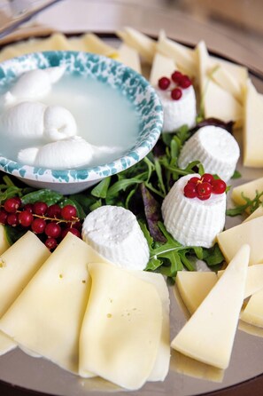 A cheese platter with various cheeses and garnishes. - Metamare (Mola di Bari)