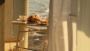 Un balcón con mesa y sillas, con vistas al mar.