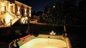 Un jacuzzi en un patio trasero, con una casa al fondo.