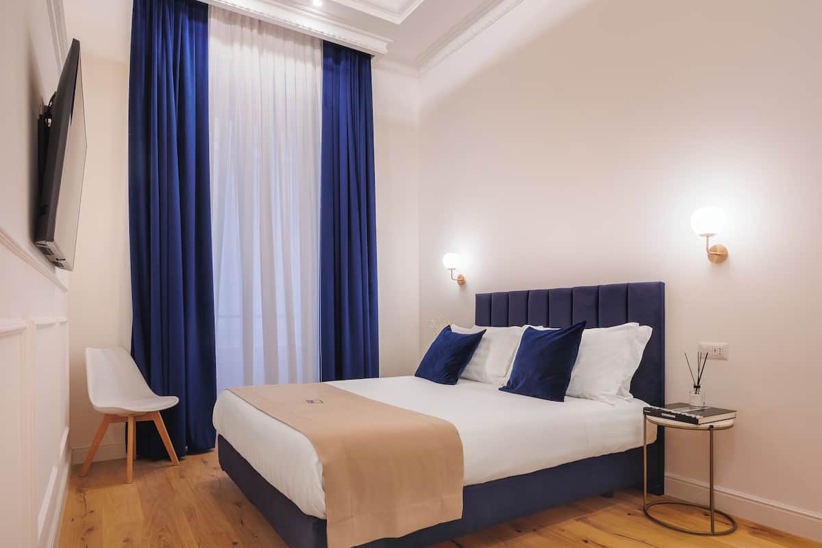 Una habitación de hotel moderna con una cama grande, un escritorio y un televisor.