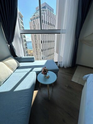 Deluxe Quadruple Room, Beach View | Living area | 55-inch Smart TV with satellite channels