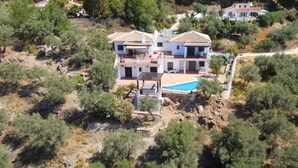 A two-story house with a swimming pool, surrounded by trees and a rocky landscape. - Villa El Dorado B&B and Wellness (Competa)