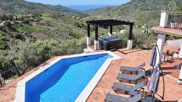 Una piscina al aire libre, sombrillas, tumbonas