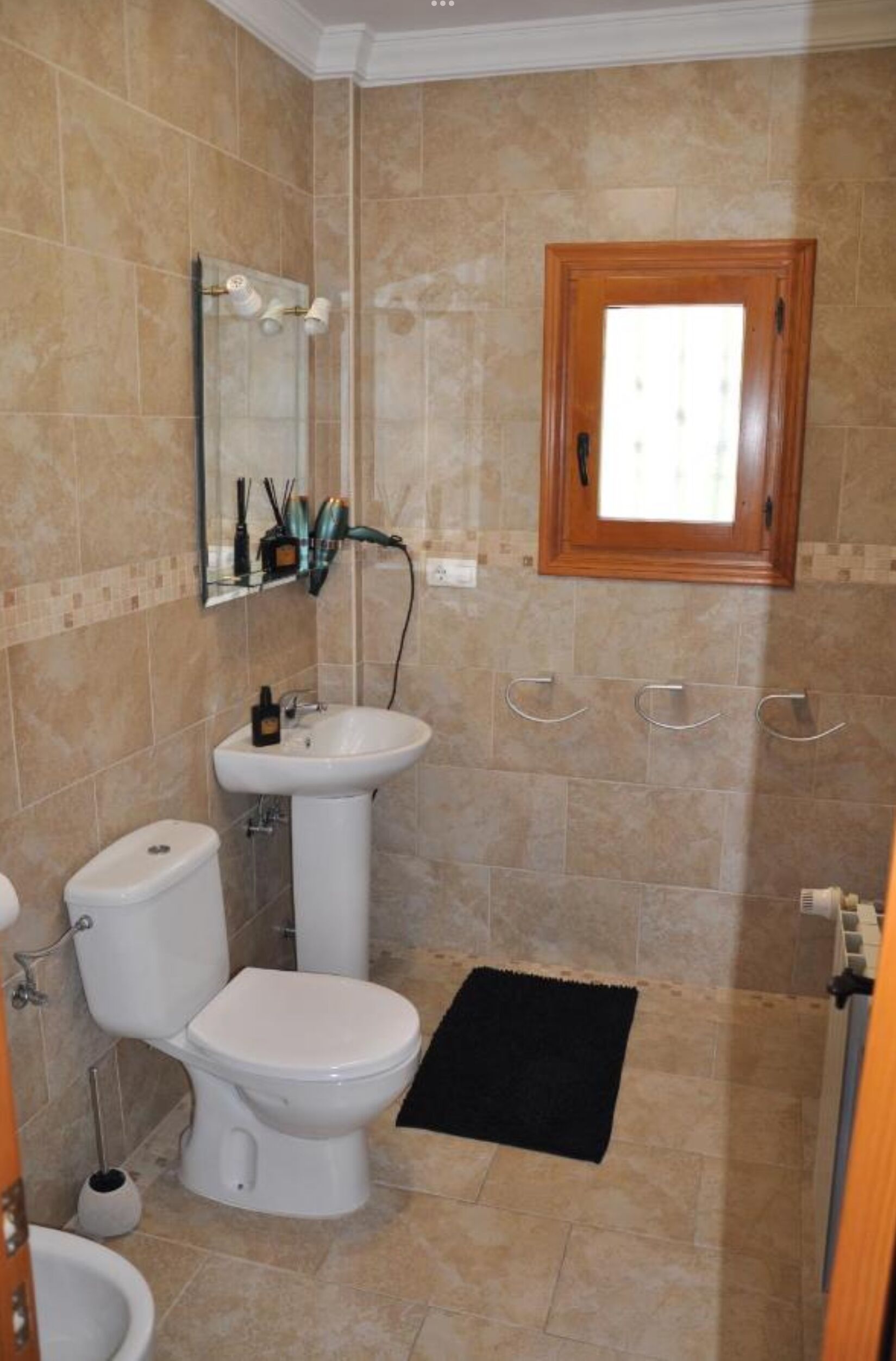 A bathroom with a toilet, sink, and shower area.