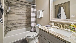 A bathroom with a shower, toilet, and sink.