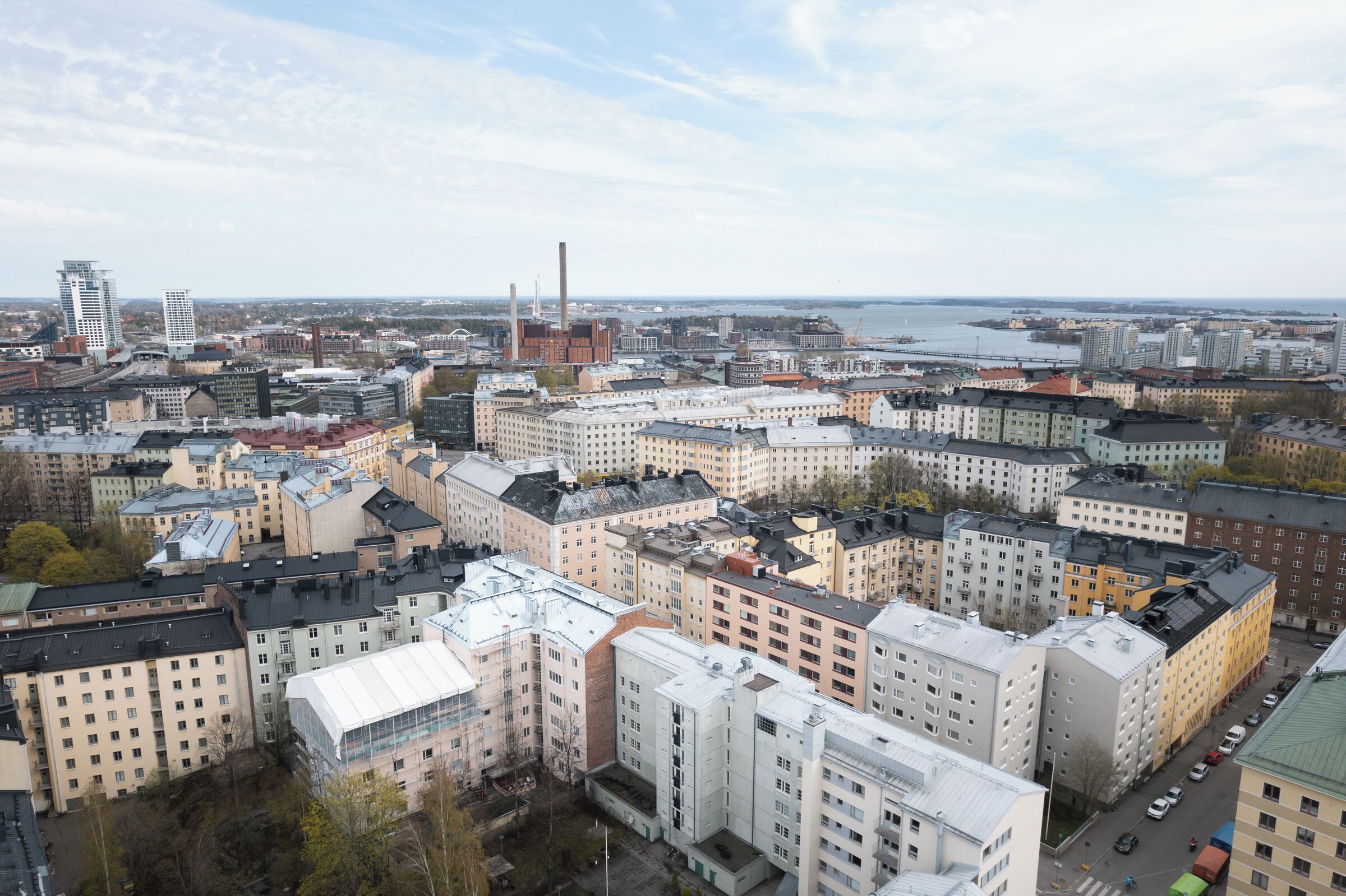 A cityscape with a mix of modern and traditional buildings, a river in the background, and a clear sky.