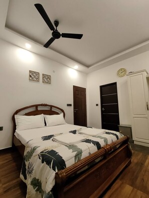 Cozy retreat with a comfortable bed, ceiling fan, and stylish decor.