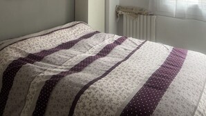 A bedroom with a bed, a painting, a radiator, and a window with sheer curtains. - Nice apartment in the center of town with spectacular views (Andorra la Vella)