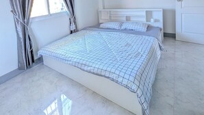 Un dormitorio con cama, cortinas, una ventana y una puerta.