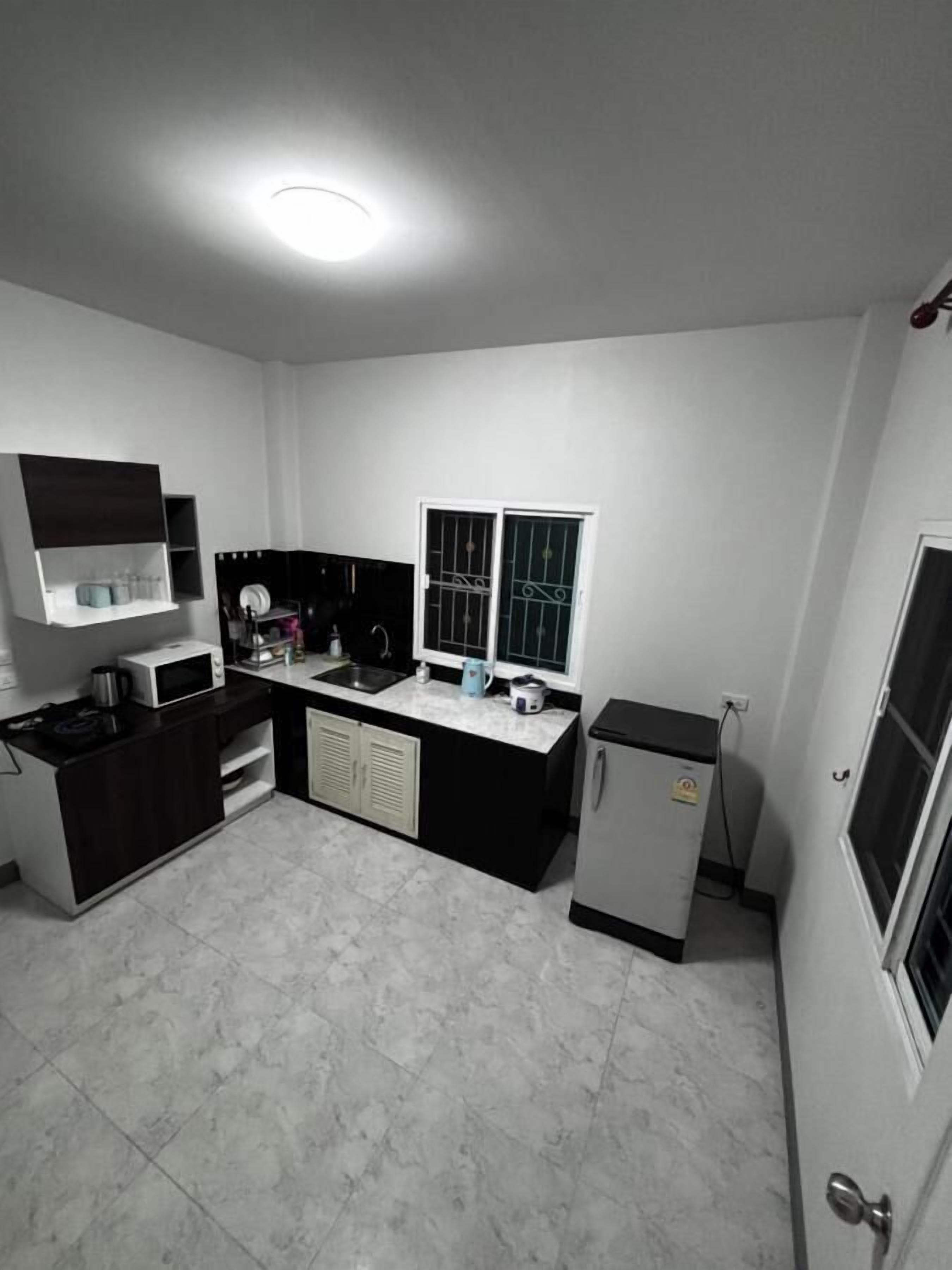 A compact kitchen with a microwave, sink, and small refrigerator.
