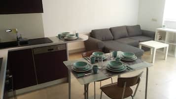 Cozy living space with a kitchenette, dining area, and seating area featuring a sofa and coffee table.