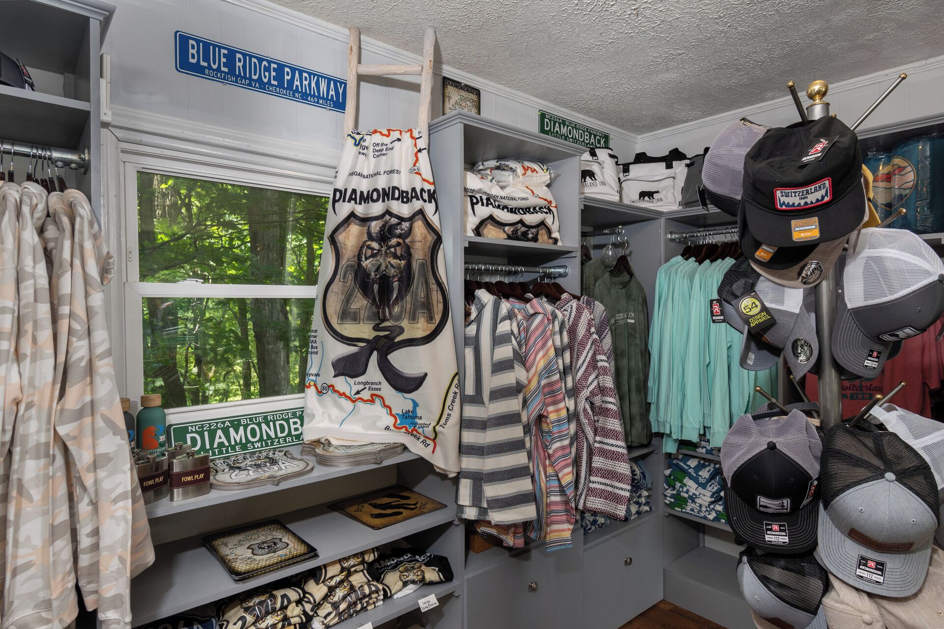 A room with a view of the Blue Ridge Parkway, featuring a rack of clothing and various souvenirs.