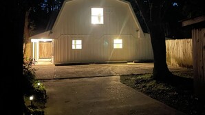 Un grand bâtiment d’un seul étage, doté d’un toit en pente, d’un garage et d’une allée menant à l’entrée.